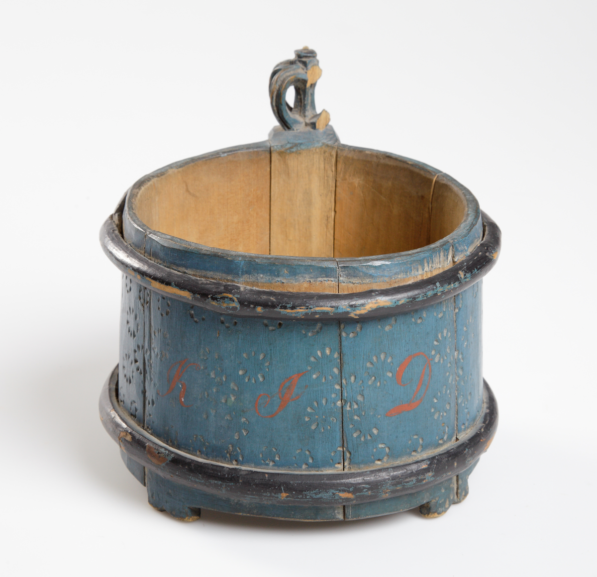 Trästånka med enkel glödritad ornering, blåmålad. Försedd med två träband samt handtaget delvis svartmålat. Saknar lock.

Inskrivet i huvudkatalog 1929.