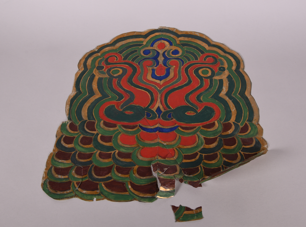 Dekorutkast til stol, av papir. Flerfarget dekor malt på papp, med elementer av gull. Symmetrisk dekor. Papiret er oppsprukket flere steder og et flak har falt av.