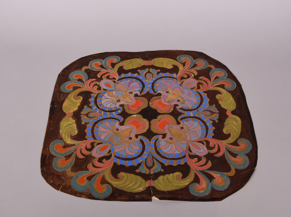 Dekorutkast til stol, av papp. Flerfarget dekor malt på papp, med elementer av gull. Firedelt, symmetrisk dekor. Innskrift på baksiden.