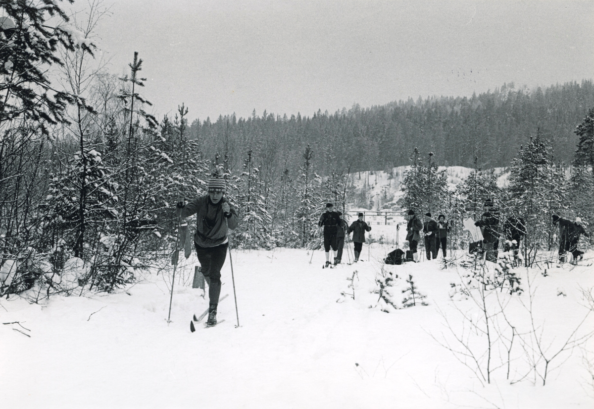 Politifolk på ski med pistolhylster rundt halsen. Pistolskyting.