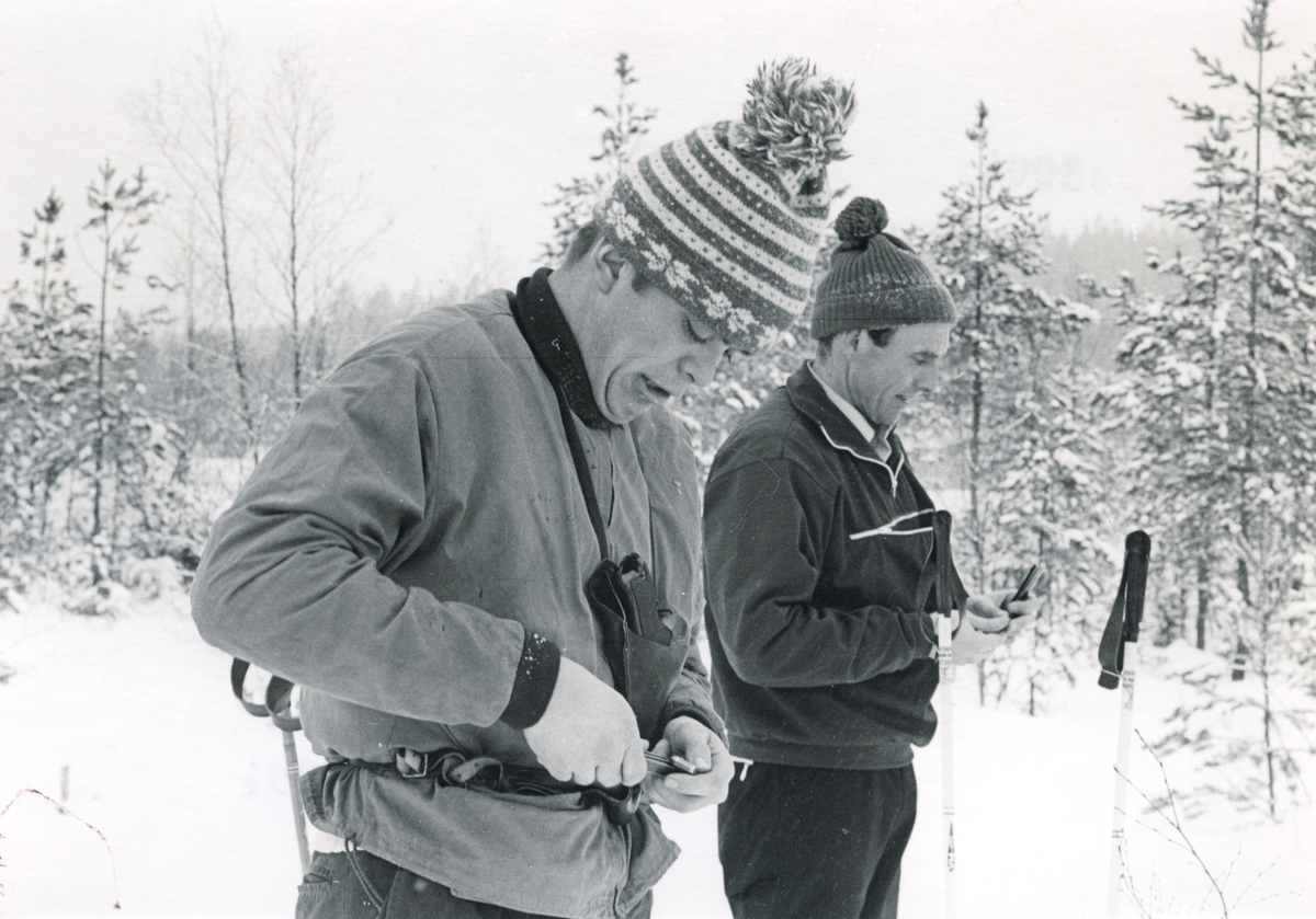 Politifolk på ski med pistolhylster rundt halsen. Pistolskyting.