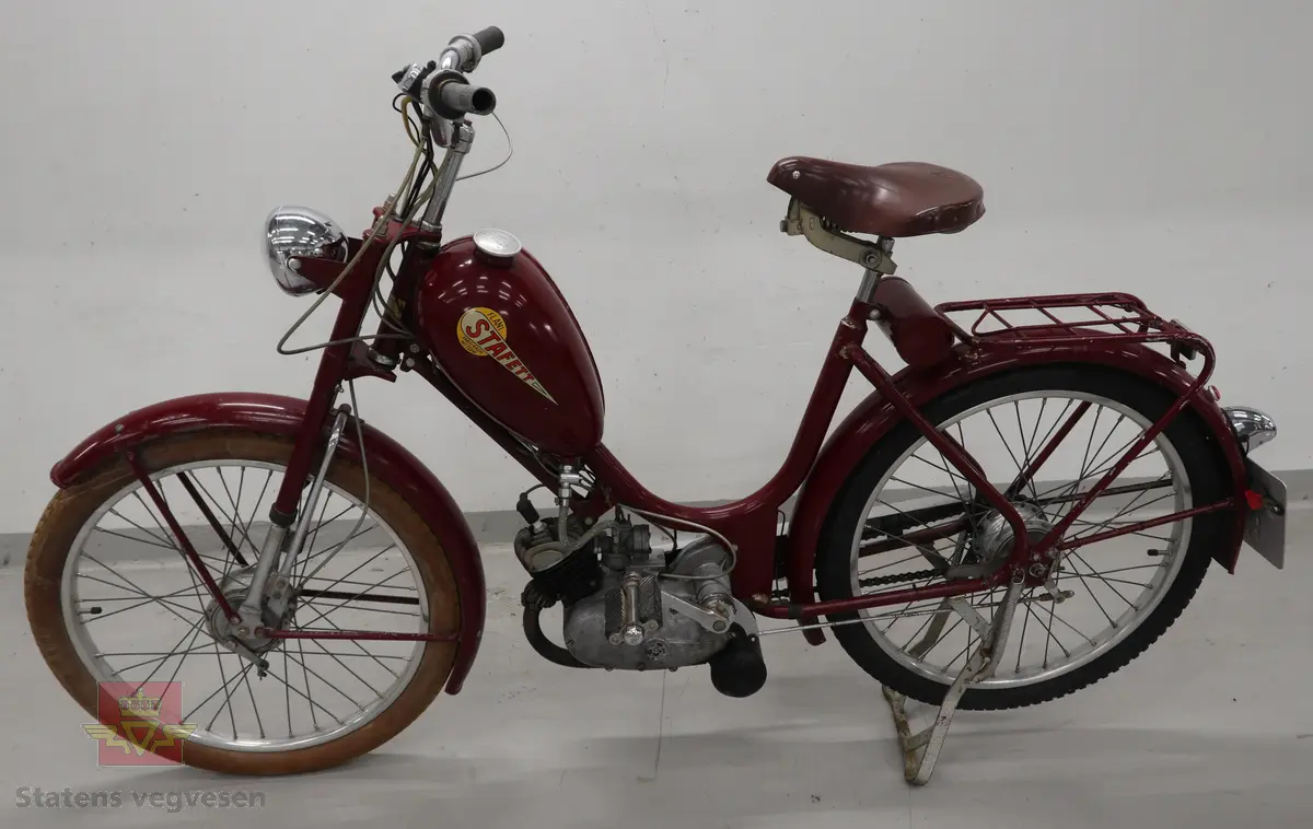 Flani Stafett type BFC-50. Mopeden er rød med svarte detaljer og flerfarget logo på begge sider av tanken. Merkeplate fra fabrikken sitter festet på gaffelen. Mopeden er utstyrt med en ensylindret BFC totakt forbrenningsmotor på 49 ccm. Motoren yter trolig 2,5 hk og går på bensin blandet med totaktsolje i forholdet 1:20 (5% olje). I tillegg til motoren har mopeden pedaler slik at man tråkke for bedre effekt i motbakkene. Mopeden har håndgir (to gir), lys og midtstøtte. Mopeden er urestaurert. og tilnærmet original. Reflekser og baklykt er ikke originale. Bakdekket er også byttet, opprinnelig var det hvitt. Framdekket er trolig det opprinnelige hvite, som har blitt misfarget. Mopeden har vindskjerm påmontert, det ser ut som nedre del av vindskjermen er hjemmelaget. Dekk er av dimensjonen 2,25 x 24.