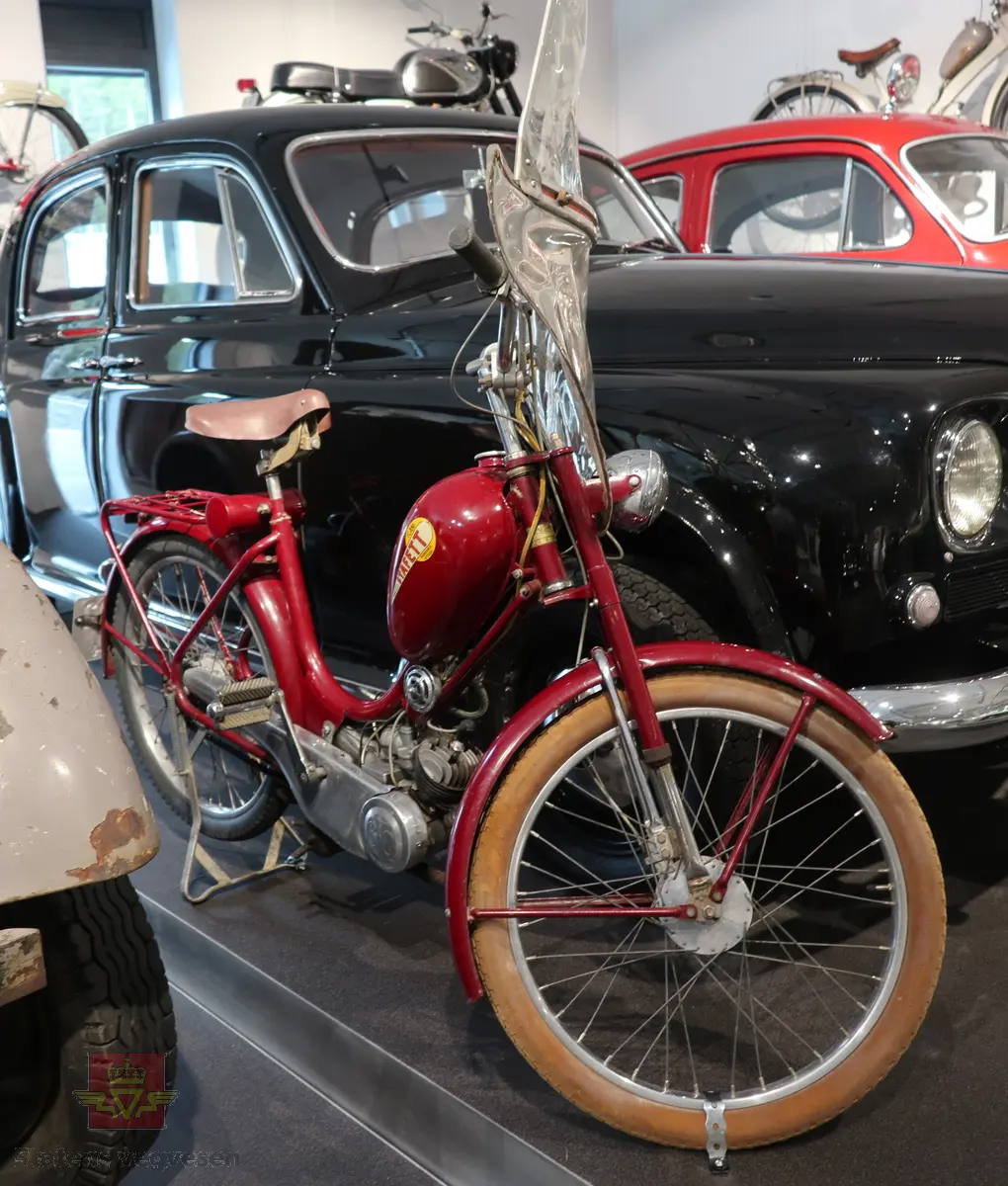 Flani Stafett type BFC-50. Mopeden er rød med svarte detaljer og flerfarget logo på begge sider av tanken. Merkeplate fra fabrikken sitter festet på gaffelen. Mopeden er utstyrt med en ensylindret BFC totakt forbrenningsmotor på 49 ccm. Motoren yter trolig 2,5 hk og går på bensin blandet med totaktsolje i forholdet 1:20 (5% olje). I tillegg til motoren har mopeden pedaler slik at man tråkke for bedre effekt i motbakkene. Mopeden har håndgir (to gir), lys og midtstøtte. Mopeden er urestaurert. og tilnærmet original. Reflekser og baklykt er ikke originale. Bakdekket er også byttet, opprinnelig var det hvitt. Framdekket er trolig det opprinnelige hvite, som har blitt misfarget. Mopeden har vindskjerm påmontert, det ser ut som nedre del av vindskjermen er hjemmelaget. Dekk er av dimensjonen 2,25 x 24.