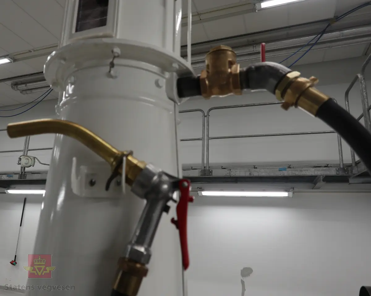 Hånddrevet pumpe, med kuppel på toppen. Kuppelen har en 220 volt lyspære. Pumpa står på en hjemmelagd sokkel av tre (det gjør den stødig og flyttbar). Maks. fyllekvantum om gangen er 20 liter. Pumpa har et skilt som viser at den ble kontrollert i 1950. Ved restaureringen ble alt tatt fra hverandre og reparert til tilnærmet ny tilstand. Kuppelen ble lagd ny. Pumpa grunnet med Owatrol og lakkert med oljemaling (Bengalakk). Fargekoder: Hvit: RAL 9016 Verkehrsweiss. Blå mørk: RAL 5013 Kobaltblau. Blå lys innvendig: RAL 5024 Pastellblau. (tatt fra et tysk RAL-kart).