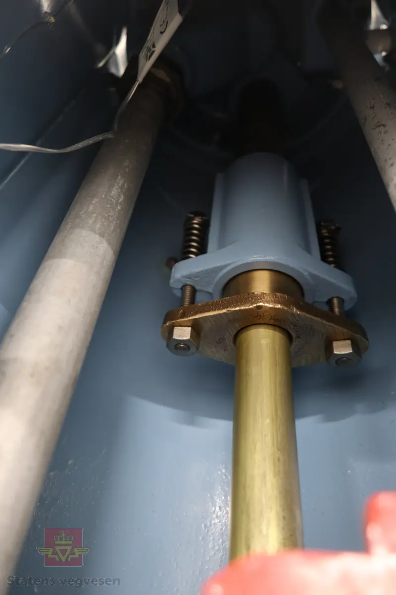 Hånddrevet pumpe, med kuppel på toppen. Kuppelen har en 220 volt lyspære. Pumpa står på en hjemmelagd sokkel av tre (det gjør den stødig og flyttbar). Maks. fyllekvantum om gangen er 20 liter. Pumpa har et skilt som viser at den ble kontrollert i 1950. Ved restaureringen ble alt tatt fra hverandre og reparert til tilnærmet ny tilstand. Kuppelen ble lagd ny. Pumpa grunnet med Owatrol og lakkert med oljemaling (Bengalakk). Fargekoder: Hvit: RAL 9016 Verkehrsweiss. Blå mørk: RAL 5013 Kobaltblau. Blå lys innvendig: RAL 5024 Pastellblau. (tatt fra et tysk RAL-kart).