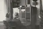 Två kvinnor sitter vid sk. telefonväxelbord, kopplar samtal för hand. Bild tagen på Drottningholm, Stockholm.