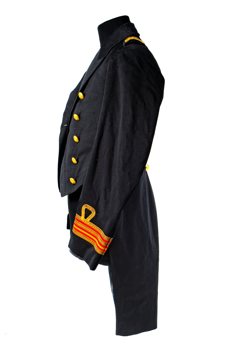 Jacka som hör till uniformen som användes av marinläkaren Anders Rudolf Prag.
Anders Prag kom tili Karlskrona 1929 som marinläkare, dispensärläkare och privatpraktiserande läkare, där hans största intresse alltid varit pediatriken, hans huvudintresse och specialitet. Anders Prag har här i staden gjort ett verkligt pionjärarbete i det att han startat barnavårdscentralsverksamheten, om vilken han aven hallit föreläsningar i Karlskrona läkareforening. I föreningen har han varit sekreterare och ordförande. Som marinläkare har Anders nått l:e marinläkargraden. De gåger han underhillit kollegerna med sång till luta, då hans sonora stamma klingat så vackert har varit verkliga högtidsstunder (ur Karlskrona Lakareförening 120 år Från hot om prygelstraff till fastställd arbetstid, SVEN SVENNERUD och HOLGER HOLMGREN 1978). "Gradbeteckningar med olikfärgat kläde mellan galonerna för civilmilitära tjänstemän med specialutbildning inom marinen; rött för marinläkare, vitt för marinintendent och lila för mariningenjör." S. 23 Flottans sjöofficersuniformer i Sjöhistoriska museets samlingar. Nils-Erik Melinder. Sida 38, samma skrift: "Från år 1937, utformades den för sjöofficeraren runda öglan till en rundad triangulär ögla, dessutom poängterad med olikfärgat kläde mellan galonerna. Statusen blev civilmilitär. Ett sammanhängande "öknamn" för den officerskategorin blev därför "päronklubben."