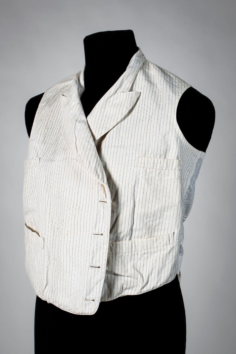 Väst som hör till uniformen som användes av marinläkaren Anders Rudolf Prag.
Anders Prag kom tili Karlskrona 1929 som marinläkare, dispensärläkare och privatpraktiserande läkare, där hans största intresse alltid varit pediatriken, hans huvudintresse och specialitet. Anders Prag har här i staden gjort ett verkligt pionjärarbete i det att han startat barnavårdscentralsverksamheten, om vilken han aven hallit föreläsningar i Karlskrona läkareforening. I föreningen har han varit sekreterare och ordförande. Som marinläkare har Anders nått l:e marinläkargraden. De gåger han underhillit kollegerna med sång till luta, då hans sonora stamma klingat så vackert har varit verkliga högtidsstunder (ur Karlskrona Lakareförening 120 år Från hot om prygelstraff till fastställd arbetstid, SVEN SVENNERUD och HOLGER HOLMGREN 1978). "Gradbeteckningar med olikfärgat kläde mellan galonerna för civilmilitära tjänstemän med specialutbildning inom marinen; rött för marinläkare, vitt för marinintendent och lila för mariningenjör." S. 23 Flottans sjöofficersuniformer i Sjöhistoriska museets samlingar. Nils-Erik Melinder. Sida 38, samma skrift: "Från år 1937, utformades den för sjöofficeraren runda öglan till en rundad triangulär ögla, dessutom poängterad med olikfärgat kläde mellan galonerna. Statusen blev civilmilitär. Ett sammanhängande "öknamn" för den officerskategorin blev därför "päronklubben."