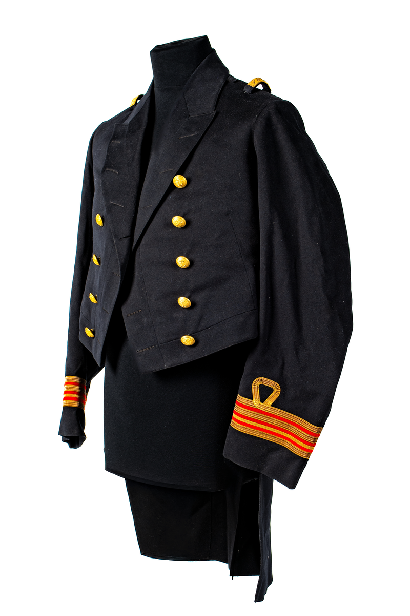 Jacka som hör till uniformen som användes av marinläkaren Anders Rudolf Prag.
Anders Prag kom tili Karlskrona 1929 som marinläkare, dispensärläkare och privatpraktiserande läkare, där hans största intresse alltid varit pediatriken, hans huvudintresse och specialitet. Anders Prag har här i staden gjort ett verkligt pionjärarbete i det att han startat barnavårdscentralsverksamheten, om vilken han aven hallit föreläsningar i Karlskrona läkareforening. I föreningen har han varit sekreterare och ordförande. Som marinläkare har Anders nått l:e marinläkargraden. De gåger han underhillit kollegerna med sång till luta, då hans sonora stamma klingat så vackert har varit verkliga högtidsstunder (ur Karlskrona Lakareförening 120 år Från hot om prygelstraff till fastställd arbetstid, SVEN SVENNERUD och HOLGER HOLMGREN 1978). "Gradbeteckningar med olikfärgat kläde mellan galonerna för civilmilitära tjänstemän med specialutbildning inom marinen; rött för marinläkare, vitt för marinintendent och lila för mariningenjör." S. 23 Flottans sjöofficersuniformer i Sjöhistoriska museets samlingar. Nils-Erik Melinder. Sida 38, samma skrift: "Från år 1937, utformades den för sjöofficeraren runda öglan till en rundad triangulär ögla, dessutom poängterad med olikfärgat kläde mellan galonerna. Statusen blev civilmilitär. Ett sammanhängande "öknamn" för den officerskategorin blev därför "päronklubben."