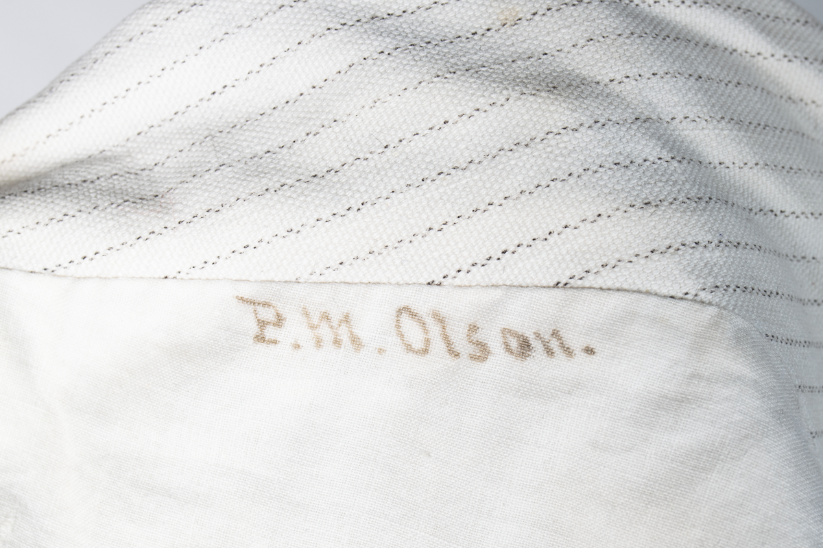 Väst som hör till uniformen som användes av marinläkaren Anders Rudolf Prag.
Anders Prag kom tili Karlskrona 1929 som marinläkare, dispensärläkare och privatpraktiserande läkare, där hans största intresse alltid varit pediatriken, hans huvudintresse och specialitet. Anders Prag har här i staden gjort ett verkligt pionjärarbete i det att han startat barnavårdscentralsverksamheten, om vilken han aven hallit föreläsningar i Karlskrona läkareforening. I föreningen har han varit sekreterare och ordförande. Som marinläkare har Anders nått l:e marinläkargraden. De gåger han underhillit kollegerna med sång till luta, då hans sonora stamma klingat så vackert har varit verkliga högtidsstunder (ur Karlskrona Lakareförening 120 år Från hot om prygelstraff till fastställd arbetstid, SVEN SVENNERUD och HOLGER HOLMGREN 1978). "Gradbeteckningar med olikfärgat kläde mellan galonerna för civilmilitära tjänstemän med specialutbildning inom marinen; rött för marinläkare, vitt för marinintendent och lila för mariningenjör." S. 23 Flottans sjöofficersuniformer i Sjöhistoriska museets samlingar. Nils-Erik Melinder. Sida 38, samma skrift: "Från år 1937, utformades den för sjöofficeraren runda öglan till en rundad triangulär ögla, dessutom poängterad med olikfärgat kläde mellan galonerna. Statusen blev civilmilitär. Ett sammanhängande "öknamn" för den officerskategorin blev därför "päronklubben."