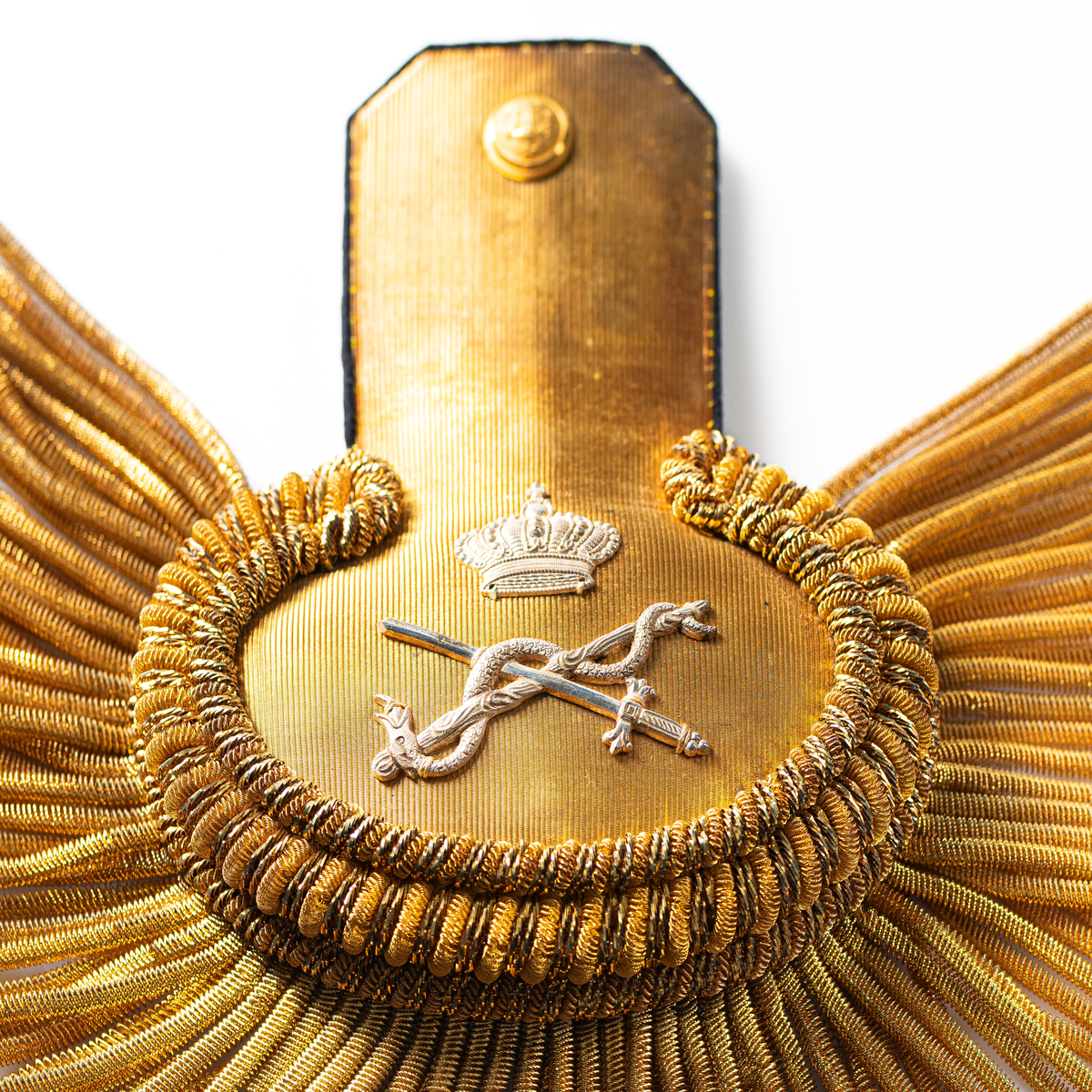 Ett par epåletter i pappask som hör till uniformen som användes av marinläkaren Anders Rudolf Prag.
Anders Prag kom tili Karlskrona 1929 som marinläkare, dispensärläkare och privatpraktiserande läkare, där hans största intresse alltid varit pediatriken, hans huvudintresse och specialitet. Anders Prag har här i staden gjort ett verkligt pionjärarbete i det att han startat barnavårdscentralsverksamheten, om vilken han aven hallit föreläsningar i Karlskrona läkareforening. I föreningen har han varit sekreterare och ordförande. Som marinläkare har Anders nått l:e marinläkargraden. De gåger han underhillit kollegerna med sång till luta, då hans sonora stamma klingat så vackert har varit verkliga högtidsstunder (ur Karlskrona Lakareförening 120 år Från hot om prygelstraff till fastställd arbetstid, SVEN SVENNERUD och HOLGER HOLMGREN 1978). "Gradbeteckningar med olikfärgat kläde mellan galonerna för civilmilitära tjänstemän med specialutbildning inom marinen; rött för marinläkare, vitt för marinintendent och lila för mariningenjör." S. 23 Flottans sjöofficersuniformer i Sjöhistoriska museets samlingar. Nils-Erik Melinder. Sida 38, samma skrift: "Från år 1937, utformades den för sjöofficeraren runda öglan till en rundad triangulär ögla, dessutom poängterad med olikfärgat kläde mellan galonerna. Statusen blev civilmilitär. Ett sammanhängande "öknamn" för den officerskategorin blev därför "päronklubben."