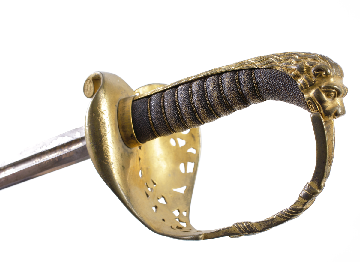 Officerssabel, möjligen modell M 1859 eller M 1899, med förgyllt mässingsfäste. Kaveln är klädd med svärtat fiskskinn, försedd med 8 räfflor lindade med snodd mässingstråd. Ryggbeslaget övergår i en kappa utförd som ett lejonhuvud. Parerplåten är enkelsidig och tillverkad av genombruten förgylld mässing. Klingan är tveeggad, försedd med blodskåror och etsade förgyllda ornament, Smålandsvapnet samt orden "Fäderneslandet" på ena sidan och "Konungen" på andra sidan.

Inskrivet i huvudbok år 1941.
