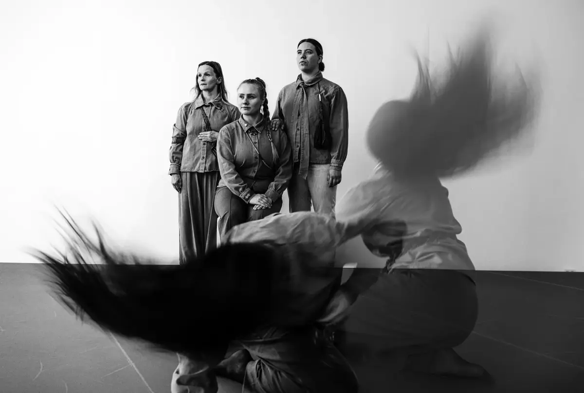 En dansare och tre andra personer som står i bakgrunden.