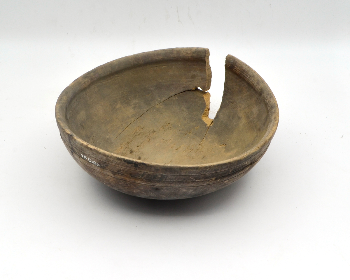 Dreid i furu. Beiset eller oljet. Rund. Profilert kant på utsiden øverst. Kanten fortykket på innsiden. Stor sprekk.
