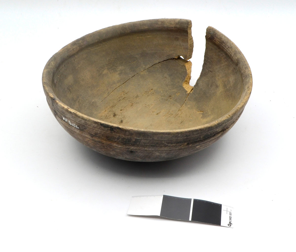 Dreid i furu. Beiset eller oljet. Rund. Profilert kant på utsiden øverst. Kanten fortykket på innsiden. Stor sprekk.
