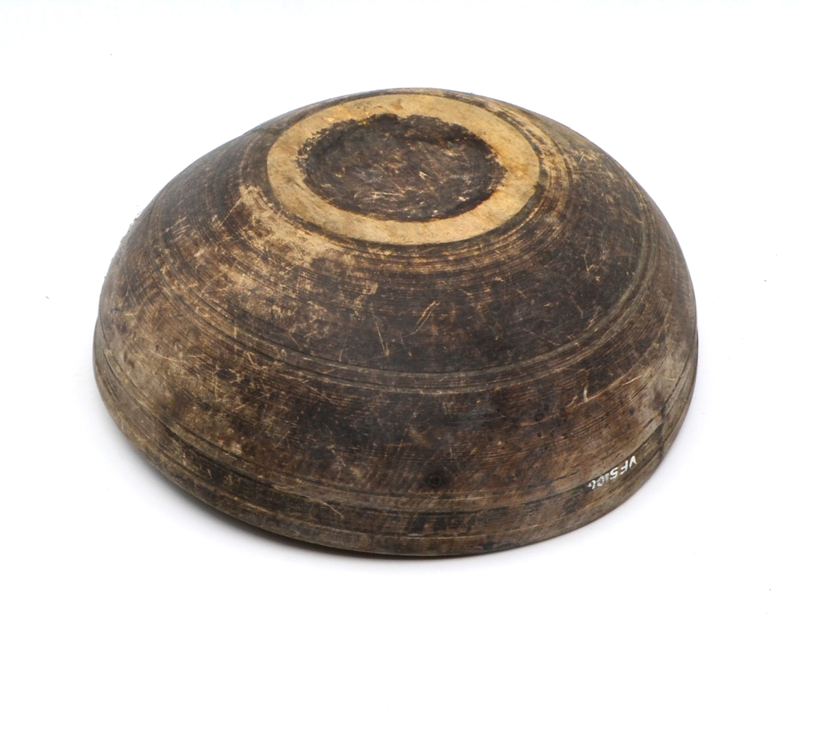 Dreid i furu. Beiset eller oljet. Rund. Profilert kant på utsiden øverst. Kanten fortykket på innsiden. Stor sprekk.