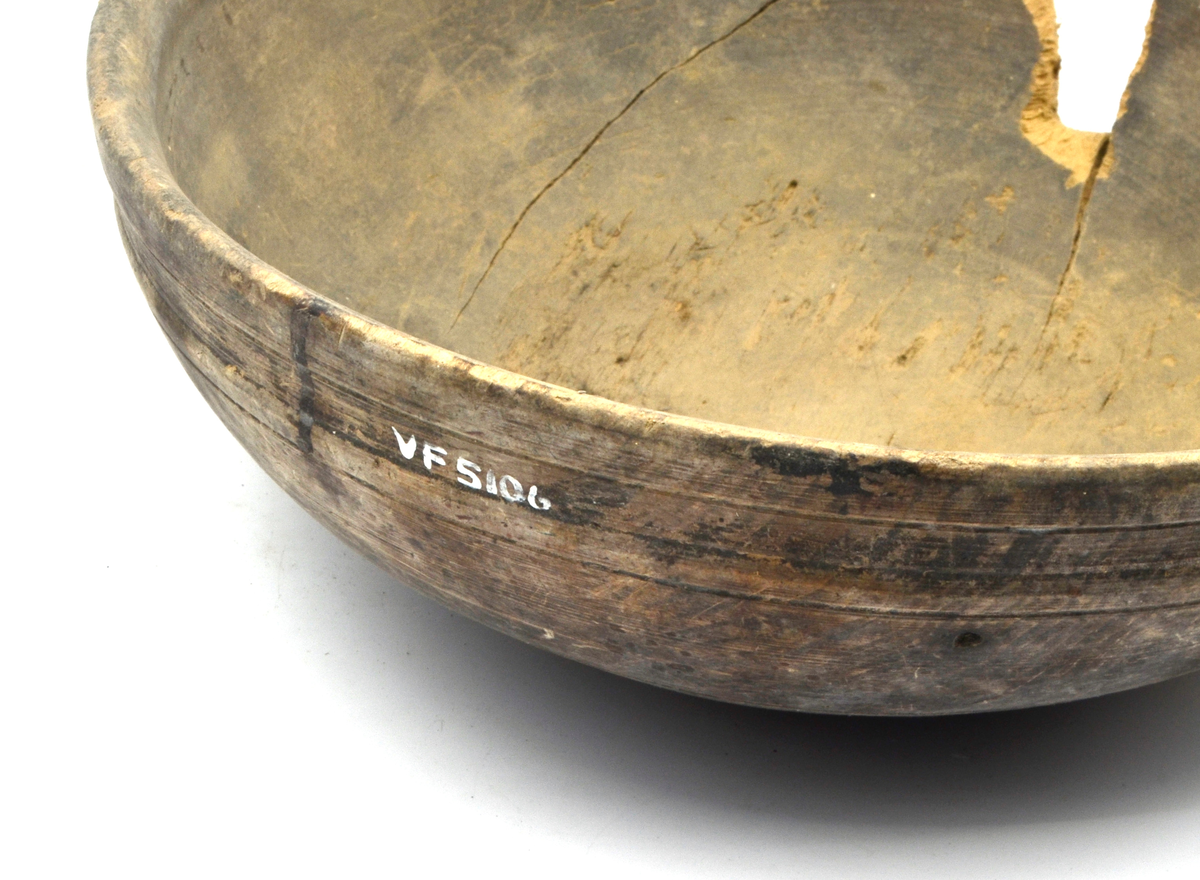 Dreid i furu. Beiset eller oljet. Rund. Profilert kant på utsiden øverst. Kanten fortykket på innsiden. Stor sprekk.