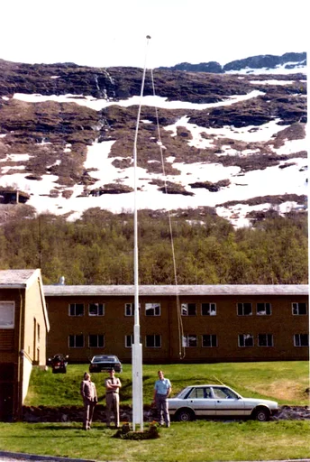 Flaggstanga ved Lstn Sørreisa etter flypass av 2 F-16 jagerfly. Festflagget hang oppe under hendelsen, og var medvirkende til at stanga ble bøyd. Fra venstre Rune Rist Grorud, ukjent og ukjent.