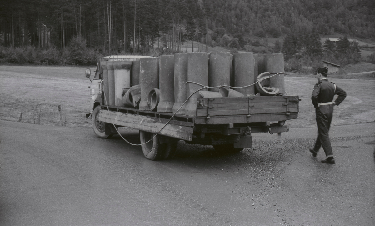 En mann går på en vei. En haug løse steiner og en sykkel ligger i veikanten.  De andre bildene viser en lastebil med betongrør på lasteplanet. Noen av rørene er knust. En politimann står ved lastebilen.