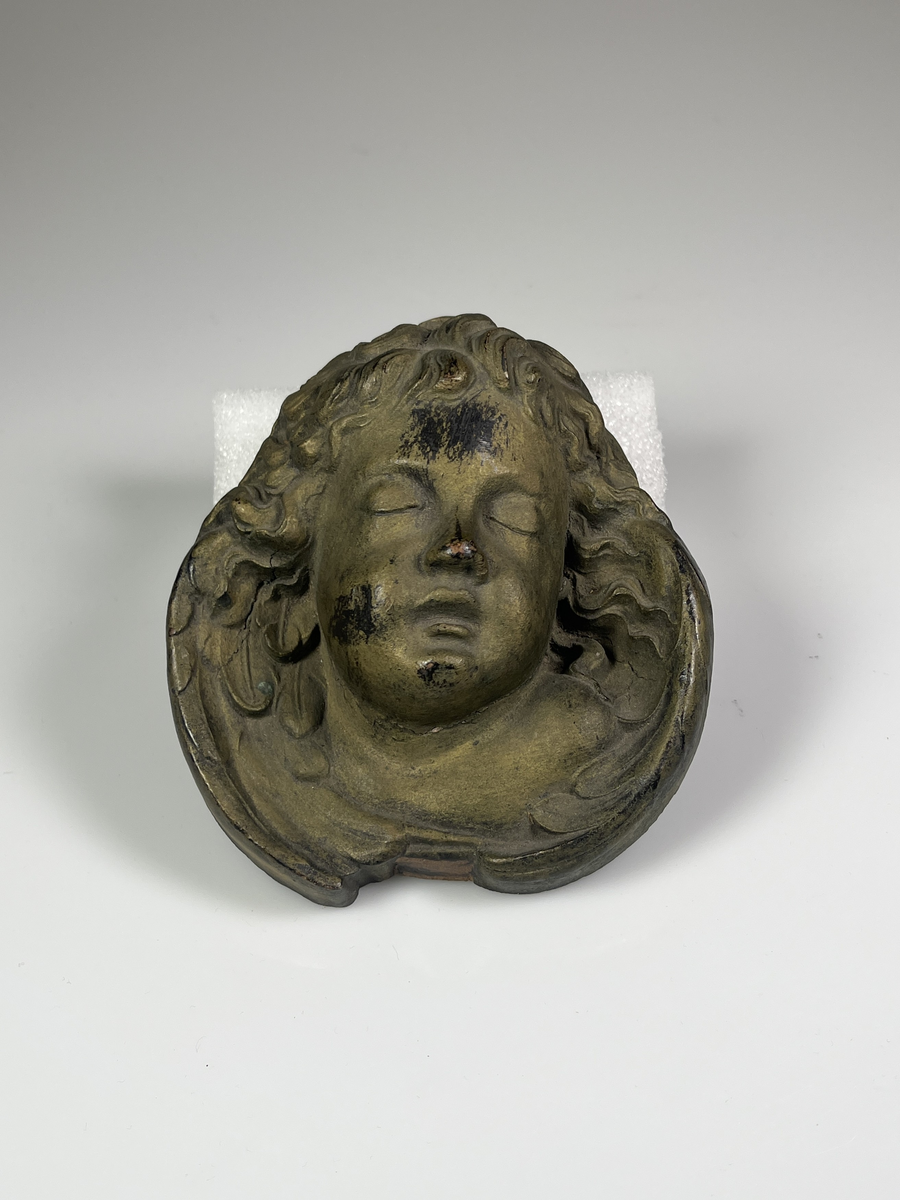 Amorinhuvud av trä. Antagligen från en kyrkoprydnad.