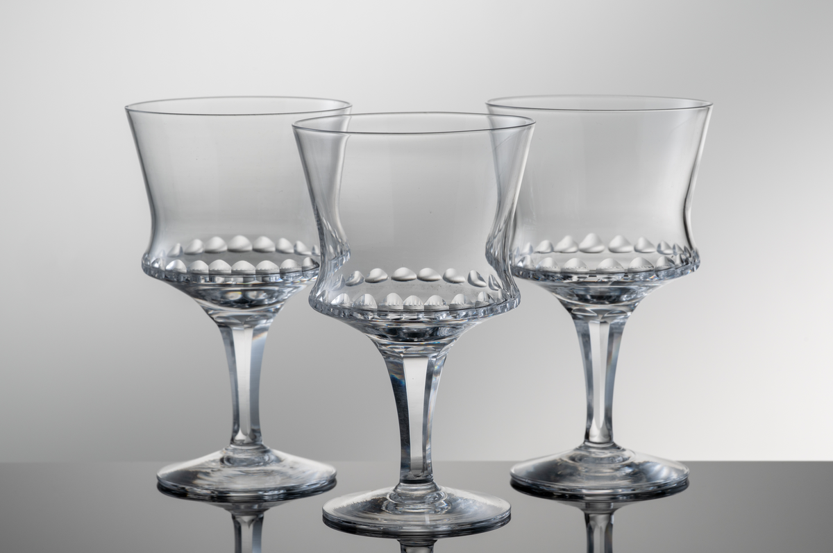 Dessertvinsglas med formblåst kupa, olivslipning runt den nedre valken och påklippt fot och ben med facettslipning.