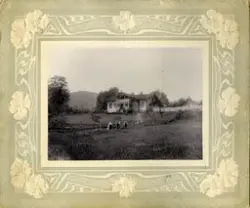 Foto av hus meg familie. Kvinner med barn står på plen foran