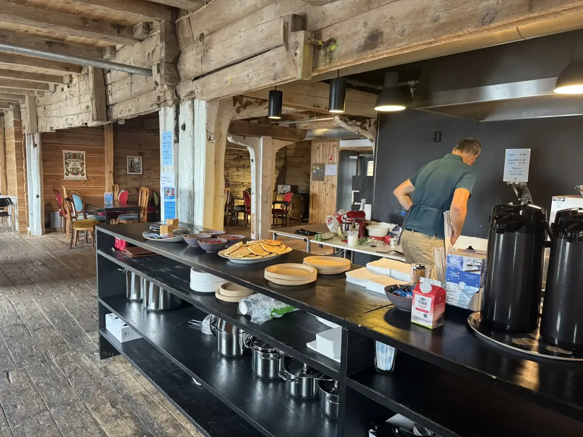 Her ser vi en mann opptatt med å steike lapper. Han står med ryggen til, men på disken i forkant av bilde kan du la deg friste av de han allerede har stekt. 