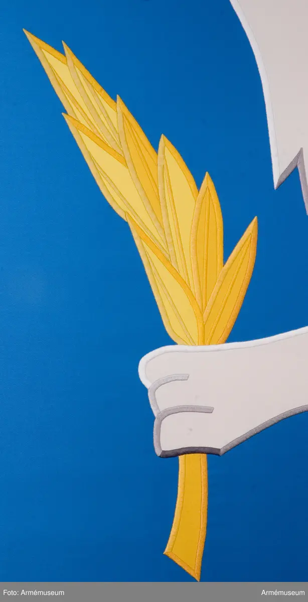 Blå fana med ett vitt lejon med röda och gula detaljer.

Fanduken är tillverkad av blått så kallat fansiden, kypertvävt, med applikationsbroderi i form av ett relativt kantigt framställt vitt lejon hållande ett gult svärd och en gul olivkvist med löv. Lejonet har röda klor och röd tunga.

Fanan är handbroderad med plattsöm, schattérsöm och applikationsbroderi. De gula detaljerna består av applicerat gult fansiden i två olika nyanser medan de röda detaljerna är broderade.

Fanstången är slät och vitmålad. Den nedre halvan mäter 118 cm varav doppskon är ca 11 cm lång och kromad, och skarvdelen av mässing är ca 18 cm.

Fanduken är märkt IB och GF 2007, troligen brodörerna Gertie Frid och Inger Broström.