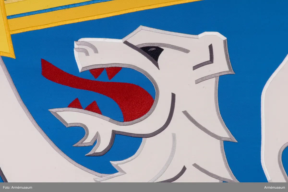 Blå fana med ett vitt lejon med röda och gula detaljer.

Fanduken är tillverkad av blått så kallat fansiden, kypertvävt, med applikationsbroderi i form av ett relativt kantigt framställt vitt lejon hållande ett gult svärd och en gul olivkvist med löv. Lejonet har röda klor och röd tunga.

Fanan är handbroderad med plattsöm, schattérsöm och applikationsbroderi. De gula detaljerna består av applicerat gult fansiden i två olika nyanser medan de röda detaljerna är broderade.

Fanstången är slät och vitmålad. Den nedre halvan mäter 118 cm varav doppskon är ca 11 cm lång och kromad, och skarvdelen av mässing är ca 18 cm.

Fanduken är märkt IB och GF 2007, troligen brodörerna Gertie Frid och Inger Broström.