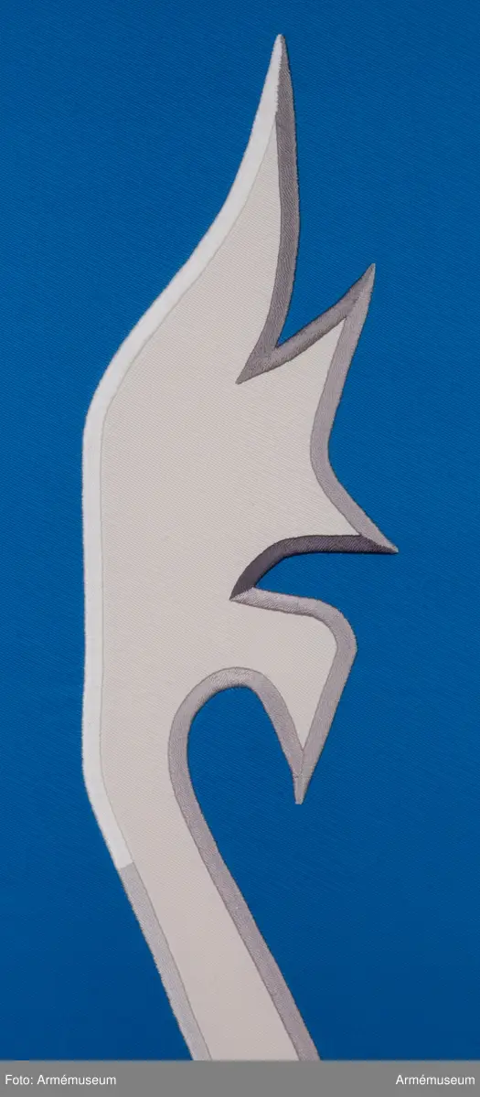 Blå fana med ett vitt lejon med röda och gula detaljer.

Fanduken är tillverkad av blått så kallat fansiden, kypertvävt, med applikationsbroderi i form av ett relativt kantigt framställt vitt lejon hållande ett gult svärd och en gul olivkvist med löv. Lejonet har röda klor och röd tunga.

Fanan är handbroderad med plattsöm, schattérsöm och applikationsbroderi. De gula detaljerna består av applicerat gult fansiden i två olika nyanser medan de röda detaljerna är broderade.

Fanstången är slät och vitmålad. Den nedre halvan mäter 118 cm varav doppskon är ca 11 cm lång och kromad, och skarvdelen av mässing är ca 18 cm.

Fanduken är märkt IB och GF 2007, troligen brodörerna Gertie Frid och Inger Broström.