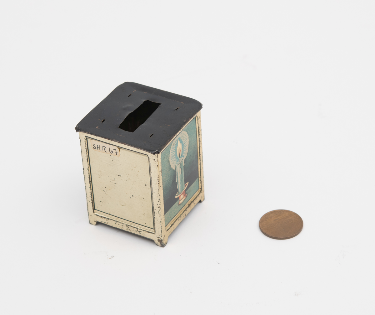 Sparebøsse i metall, med motiv av brennende stearinlys, med en 5 øre i sparebøssen.