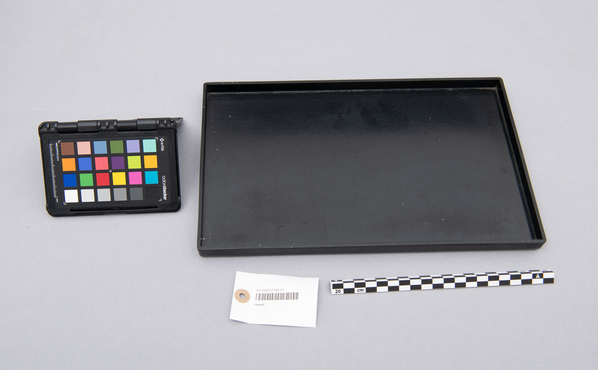 Myntkassett i svart bakelitt, inneholdende 8 behoholdere sortet på de ulike valørene 1, 2, 5, 10, 25 og 50 øre. 1 og 5 kroner. Hvit skrift.
