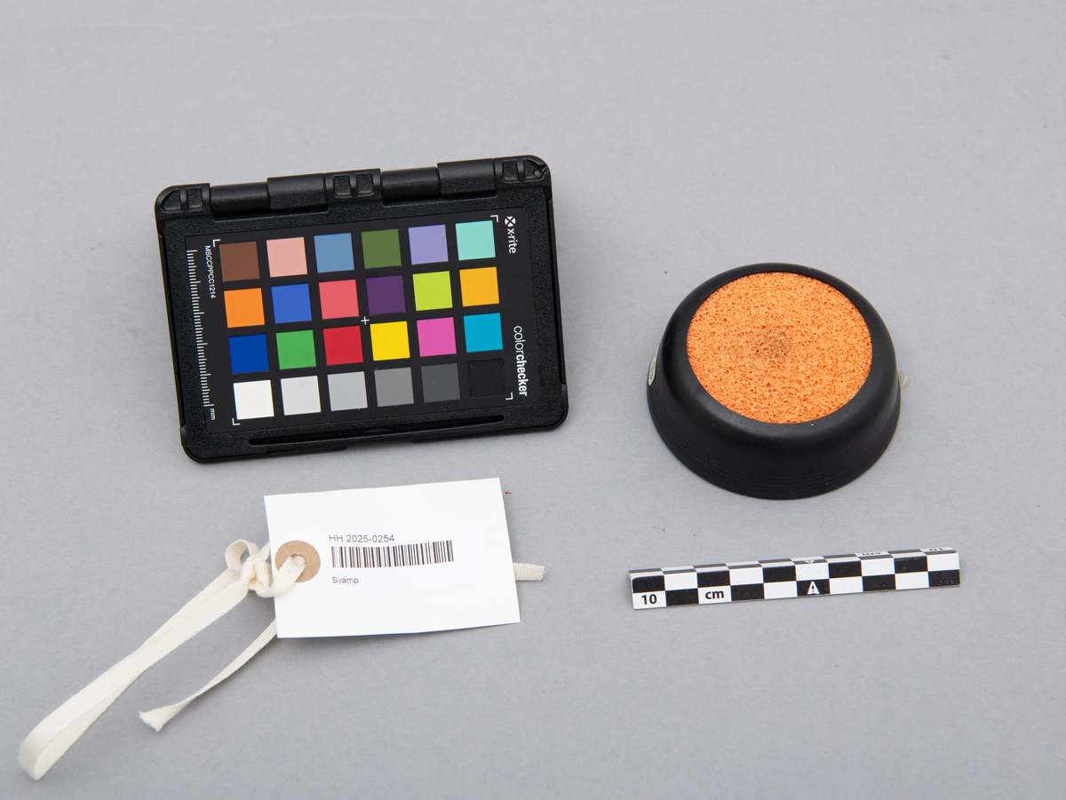 Svamp for fukt av fingre. Holder i svart plast. Oransje svamp av gummi.