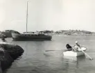 Motorseglaren PIRAYA ligger förtöljd i Ålands skärgård sommaren 1959. I roddbåt syns PIRAYAS 