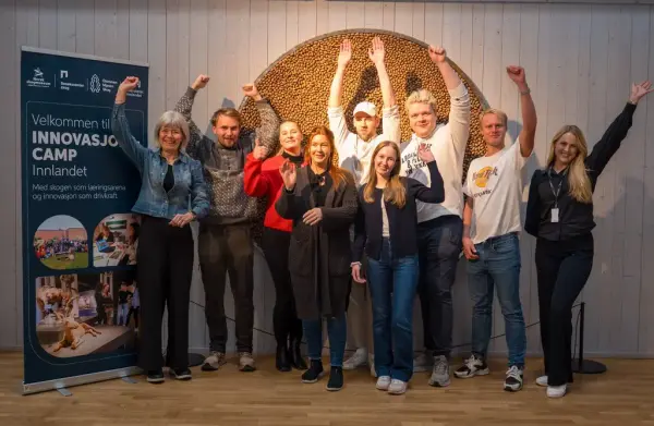 en rekke personer jubler med hendene i været 