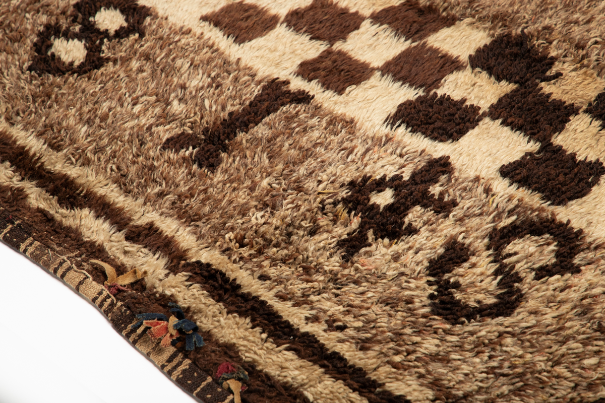 Håndlaget rye i ull, flossteknikk, Bunnen består av treskaftet kyper (stoff vevd med et mønster av skrå linjer), sydd sammen av tre bredder. Fargene er hvitt, sauesvart, brunt og brunmelert. Glattsiden er stripet på langs. På flossiden er det i den ene enden hvite og brune tverrstriper og et felt med brune ruter på hvit bunn (sjakkbrettruter). Mellom disse felt et brunmelert felt hvori initialer og årstall: "A S P  1816". Resten er brunmelert. Stoffdusker øverst i rød, blå og sauehvit ull.