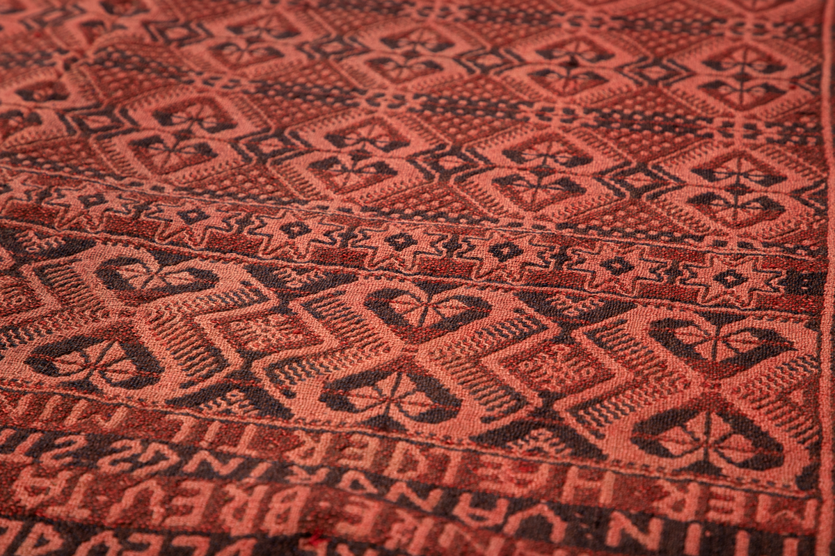 Åkle i dobbeltvev (også kalt Meråkervev eller flensvev). "Spigilåklæ" i svart og rødt med tradisjonelt geometrisk mønster.

Innvevd innskripsjon øverst på den ene halvpart: "E O S. NU EN DAG IEG ÆLDRE BLEV. DET ER SOM MIT TANKE BREV. TA IEG MED MIN VANDRINGS STAF. NÆRMER HÆLDER TIL MIN GRAV." På annen halvdel: "ANNO 1799. IEG VIL TIL SOVE STÆDEN GAA. TI HVILE MIG BEHAGER. AT IEG DES BEDRE SOVE. MAA MIN KLÆDNING IEG AFDRAGER. NO 17."