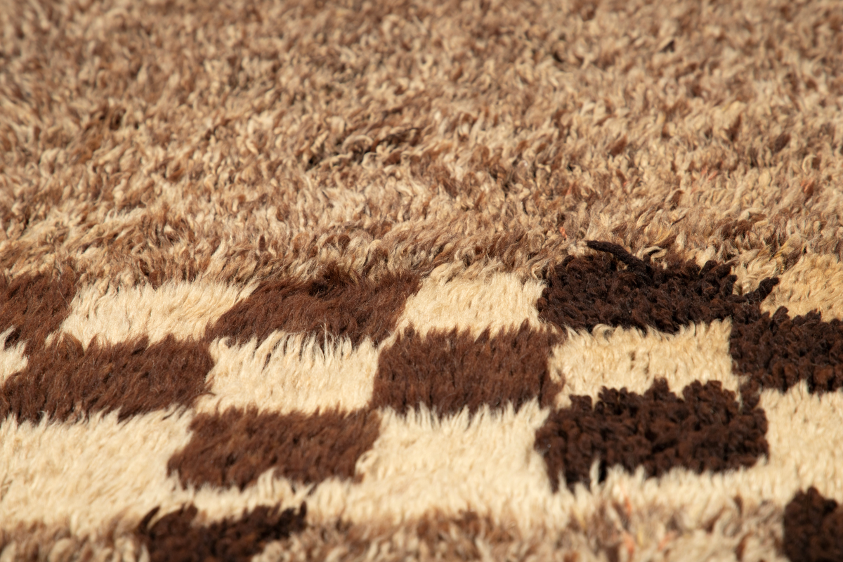 Håndlaget rye i ull, flossteknikk, Bunnen består av treskaftet kyper (stoff vevd med et mønster av skrå linjer), sydd sammen av tre bredder. Fargene er hvitt, sauesvart, brunt og brunmelert. Glattsiden er stripet på langs. På flossiden er det i den ene enden hvite og brune tverrstriper og et felt med brune ruter på hvit bunn (sjakkbrettruter). Mellom disse felt et brunmelert felt hvori initialer og årstall: "A S P  1816". Resten er brunmelert. Stoffdusker øverst i rød, blå og sauehvit ull.