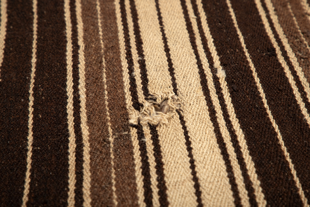 Håndlaget rye i ull, flossteknikk, Bunnen består av treskaftet kyper (stoff vevd med et mønster av skrå linjer), sydd sammen av tre bredder. Fargene er hvitt, sauesvart, brunt og brunmelert. Glattsiden er stripet på langs. På flossiden er det i den ene enden hvite og brune tverrstriper og et felt med brune ruter på hvit bunn (sjakkbrettruter). Mellom disse felt et brunmelert felt hvori initialer og årstall: "A S P  1816". Resten er brunmelert. Stoffdusker øverst i rød, blå og sauehvit ull.