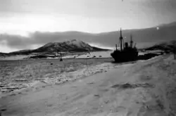 Transportskip ved kai i Hamnbukt etter solnedgang vinteren 1