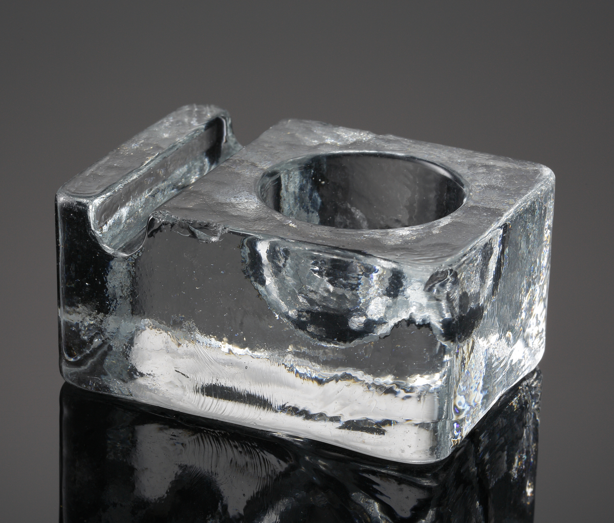 Gjutet askfat med rund nedsänkning och fåra.
