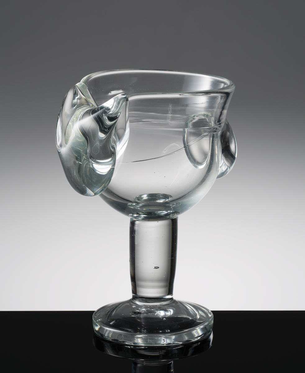 Driven pokal med tjockt cylindriskt ben med blåsa, påklipp som liknar en knapp och en tunga.