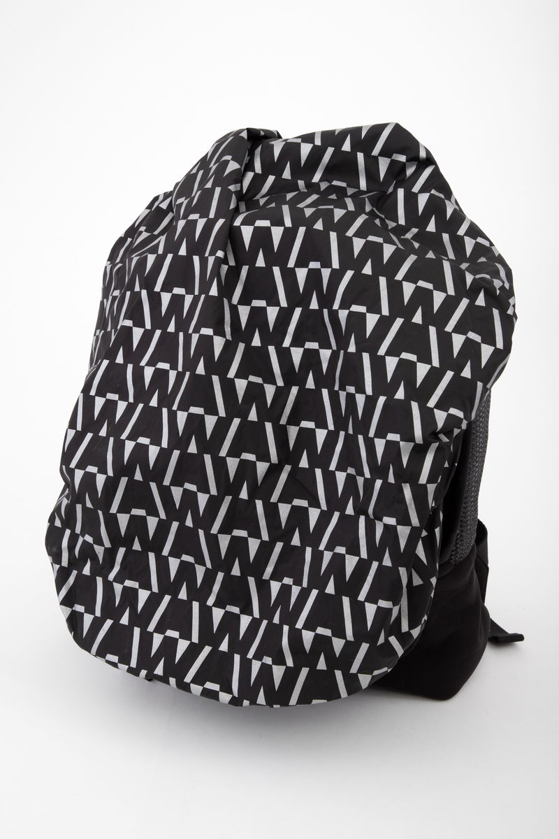 Liten sekk for trening. Sydd av nettstoff, der det ytre stoffet er laminert med flere lag nettstoff, og kjernen antagelig selvlysende, dvs av lysegrå refleksfibre. Sekken består av ett hovedrom og et lite ytterrom. Nedre del av både sekk og ytterrom er av tett neopren. Selve bunnen har en påsydd plate av gummi, med 4 "ben" i form av logoen "AW".  Innvendig bunnplate er imidlertid både bredere og lengre og av ukjente materiale. Sekken er flat nederst og buet i overkant, hovedrommet åpnes nesten helt ned i begge sider og lukkes med grov plastglidelås. Ytterommet åpnes i overkant og lukkes med tilsvarende glidelås. Innvendig er rommene fôret med et ekstra lag, enkelt nettstoff, og hovedrommet utstyrt med en ekstra lomme. Selene er regulerbare med spenner, er polstret, av neopren og utvendig forsterket med påsydde bånd av bevernylonlignende materiale ivevd "WANG" gjentatte ganger. Tilsvarende stropp øverst, til bæring i hånden. Under selefestene en ekstra lomme, lukket med samme grove glidelåstype. Nedi lommen ligger et påsydd regntrekk av tynt, vannavstøtende matriale, med påtrykt "AW" i et sammenhengende mønster utført i lysreflekterende trykkfarge over det hele. Med påsydd elastikk langs ytterkanten, kan trekket raskt tas ut og vikles omkring sekkens front og holde seg på plass i regnvær. Alle glidelåser er utstyrt med en "drastropp" av det sorte båndet ivevd WANG.