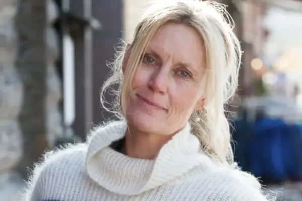 Dette er et portrett foto av en kvinne med langt hår. Det er Guri Jortveit.