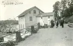 Delar av familjen Karlén och Malmström på promenad på landvägen vid Hjulsbro. I bakgrunden syns en kvarn i Stångån.