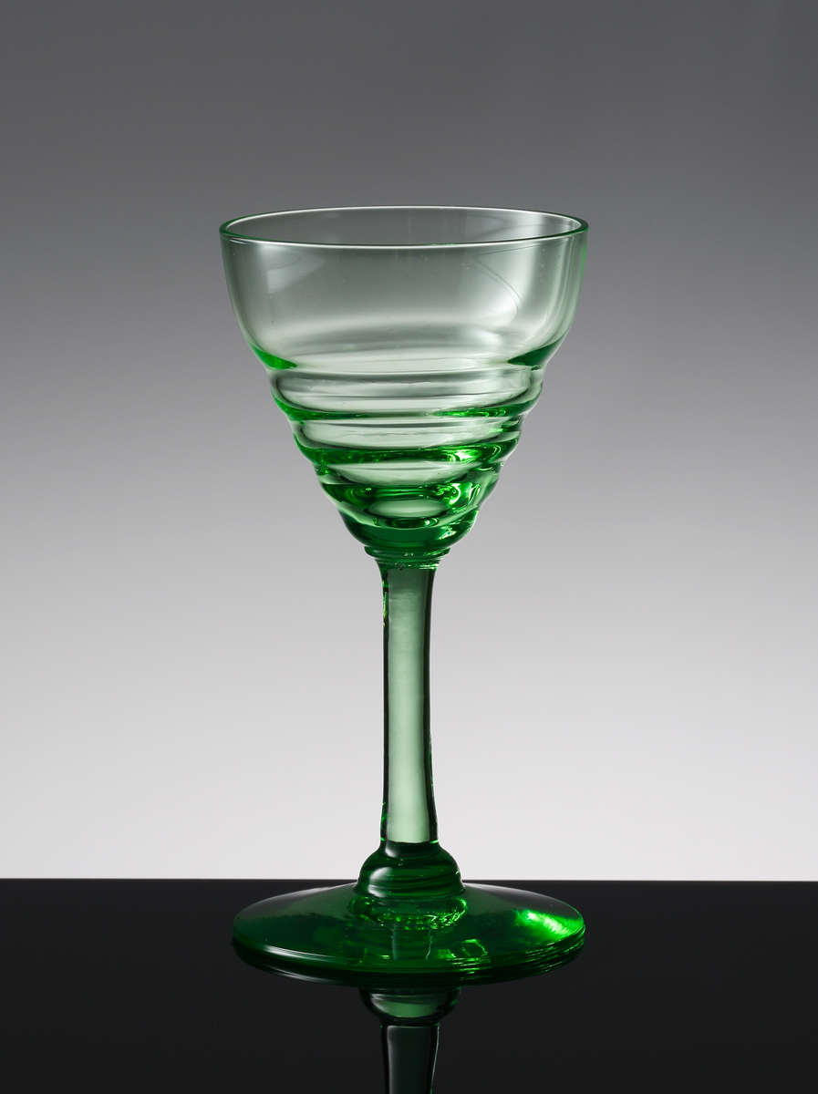 Ljusgrönt litet vinglas (2 1/2 cl) med valkar på nedre delen av den konande kupan.