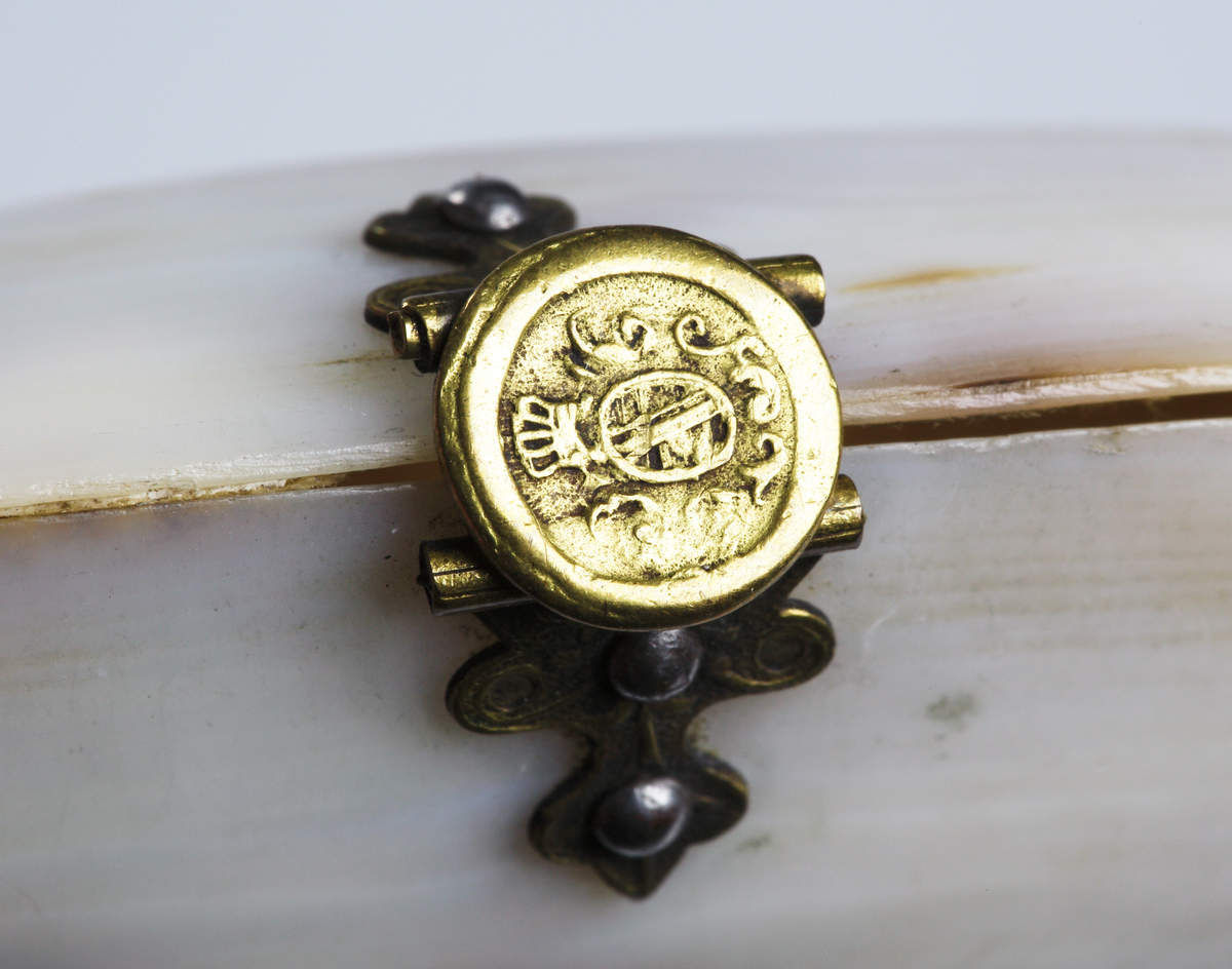 Etui, av musselskal med beslag av mässing.
Inskrivet i huvudkatalog 1936.