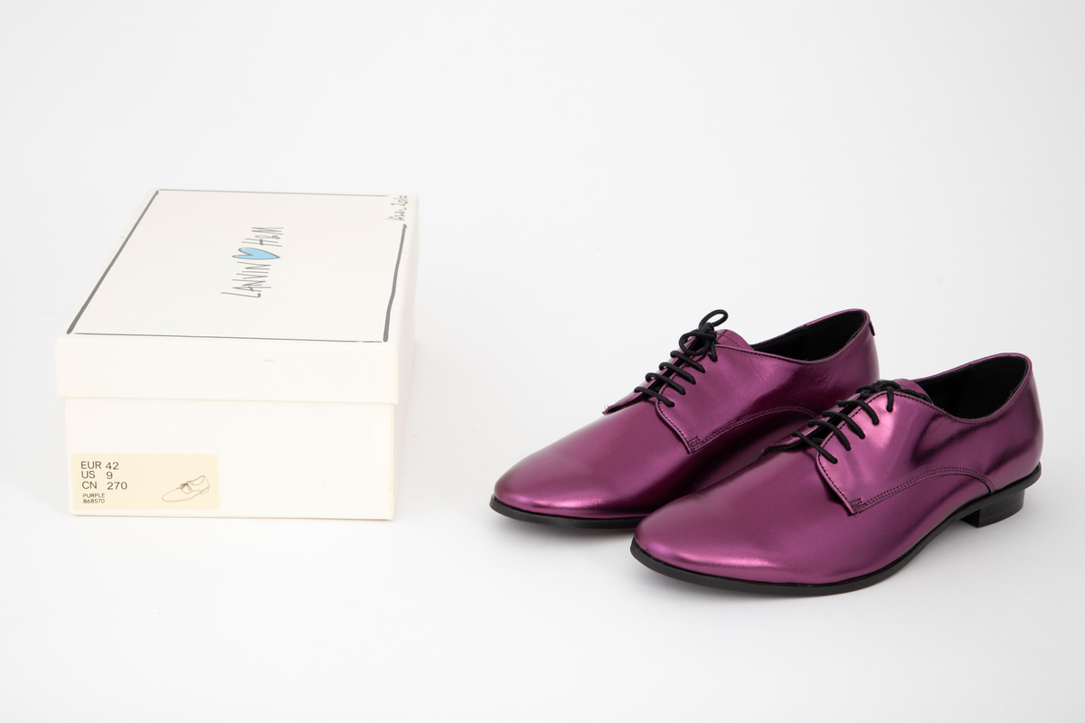 Herresko, metallisk rosa, avrundet foran med fem hull på hver side og rund svart lisse. Lav hæl med svart kant rundt skoen.