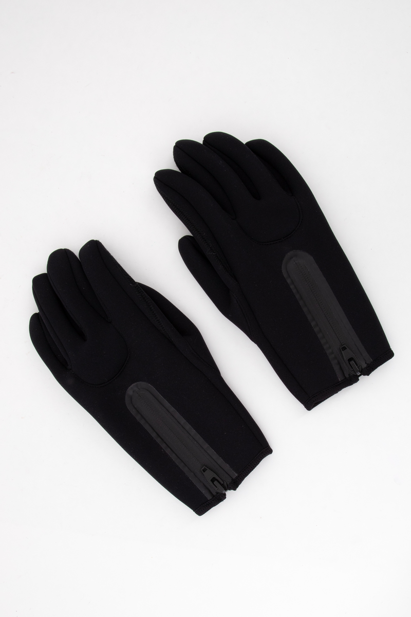 Korte, laminerte hansker, lukket på yttersiden av påsveiset gummi- og plastglidelås. Innfelt to-blads tommel og innfelt ytterside for ring- og langfinger. Mange sømmer vrangsydd og sømmene mellom fingrene av "flat overlock". Langs åpningen påsydd strikket "skråbånd".