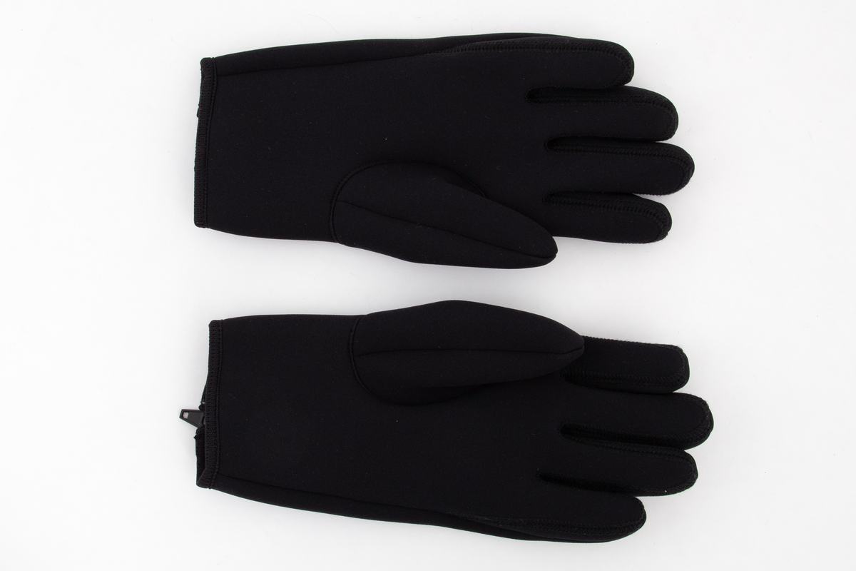 Korte, laminerte hansker, lukket på yttersiden av påsveiset gummi- og plastglidelås. Innfelt to-blads tommel og innfelt ytterside for ring- og langfinger. Mange sømmer vrangsydd og sømmene mellom fingrene av "flat overlock". Langs åpningen påsydd strikket "skråbånd".